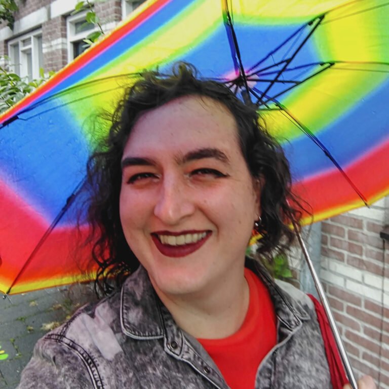 Portrait picture of Lu holding a multicolored umbrella